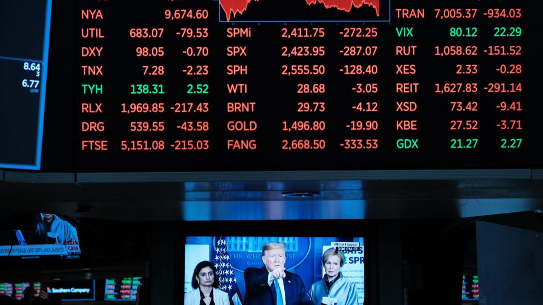 Stocks falling sharply at the NYSE and Trump discussing the corona virus on the news displayed on a television