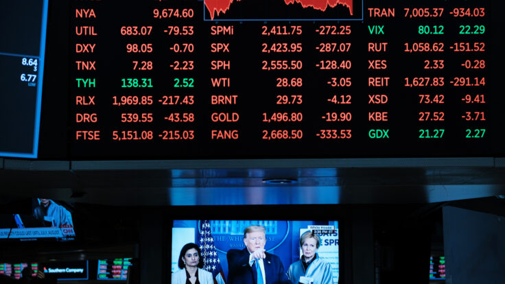 Stocks falling sharply at the NYSE and Trump discussing the corona virus on the news displayed on a television